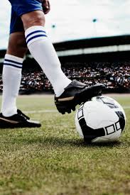 Piede di calciatore su pallone in stop con plantare sportivo biomeccanico MEDERE per calcio